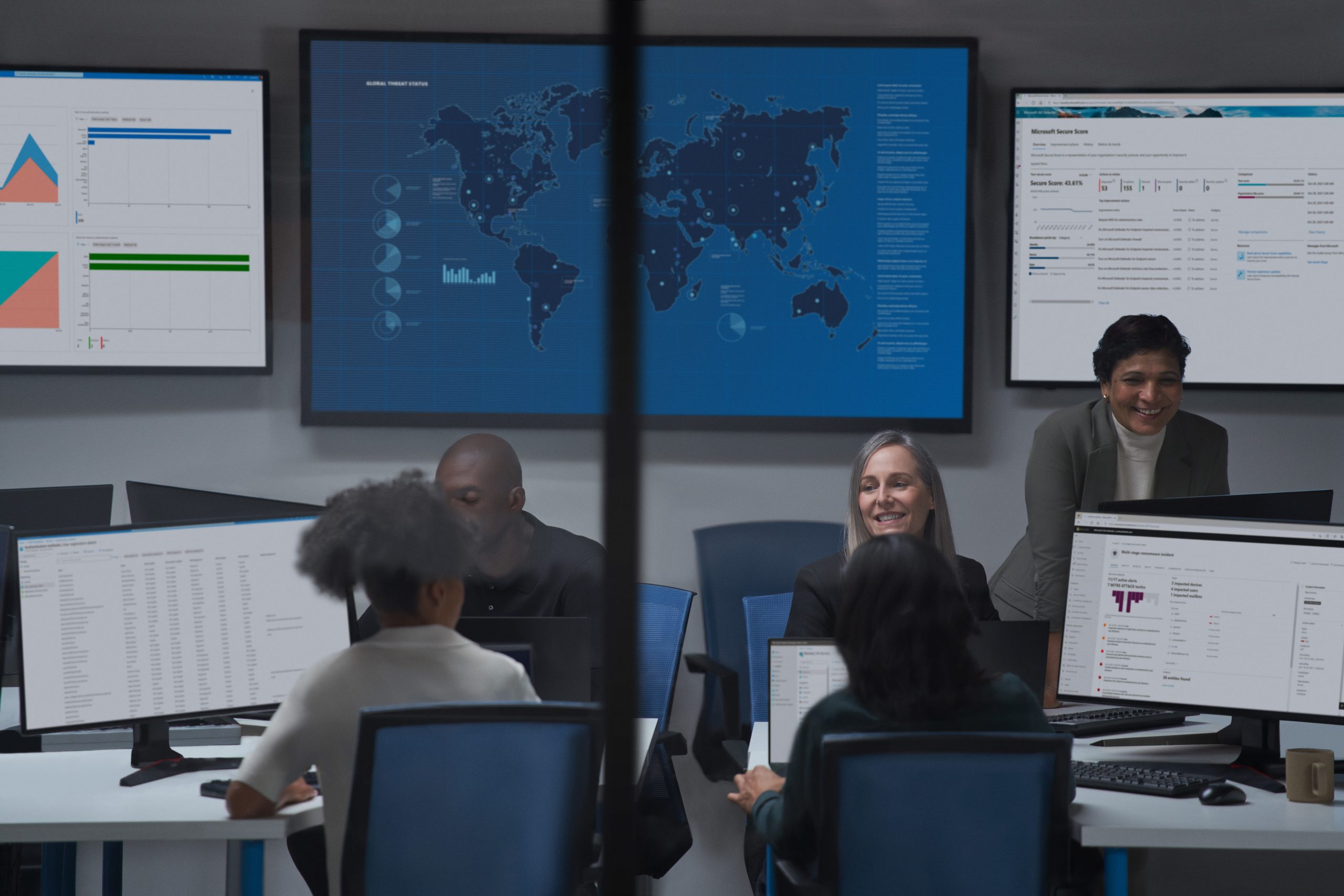 Image of a cybersecurity center with people and computer screens