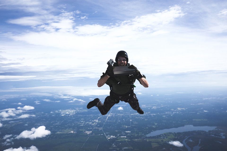 Профессиональный каскадер Тройс Пастран летит с высоты птичьего полета с консолью ограниченной серии Xbox One X «Золотая лихорадка» в руках