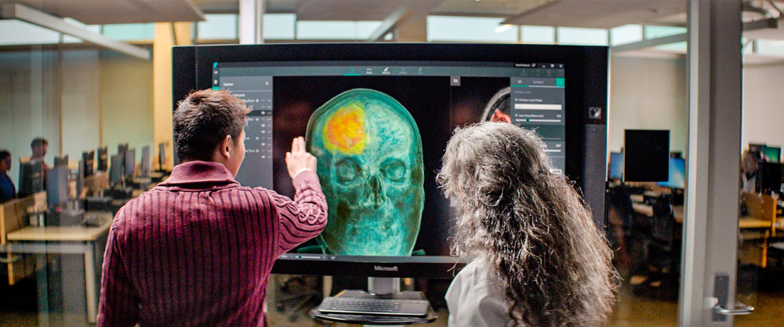 Мужчина и женщина разглядывают изображение черепа на цифровой панели