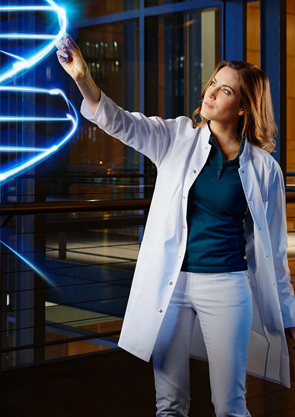 Девушка в медицинском халате и светящаяся модель ДНК