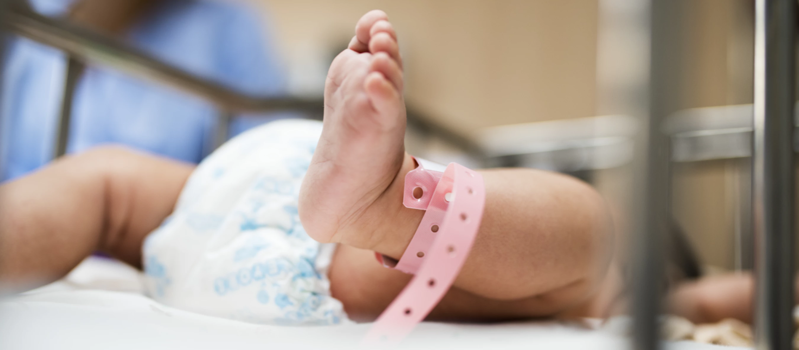 Ножка новорожденного малыша с пластиковым браслетом
