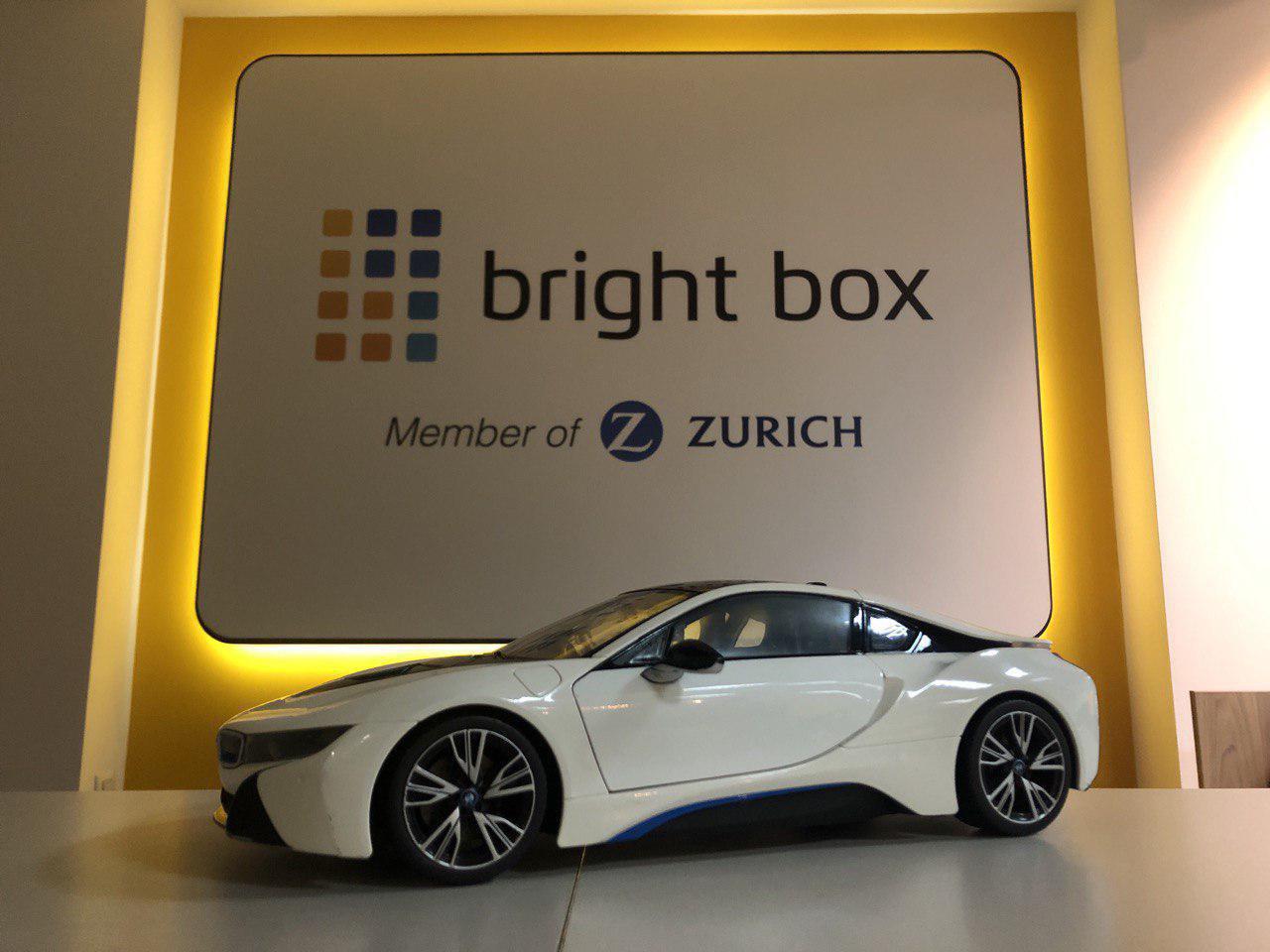 Автомобиль стоит у стены с логотипом Bright Box