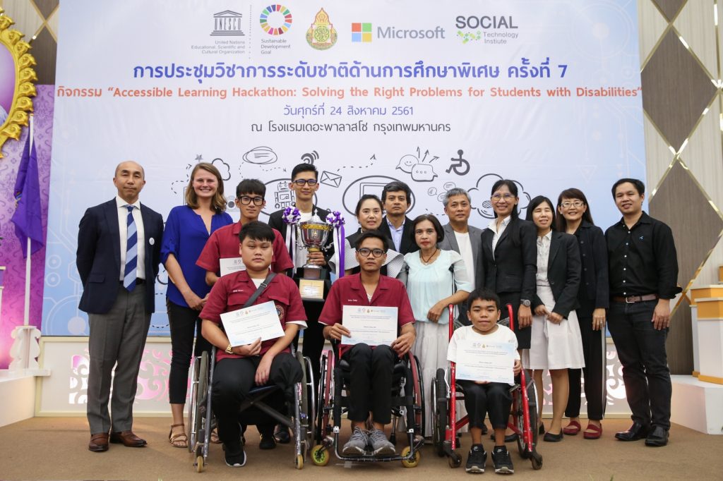 Group of people with three students in wheelchairs holding certificates