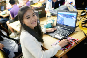 Girl using laptop and smiling at camera