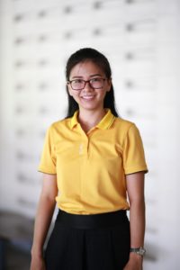 Smiling young woman in yellow polo shirt