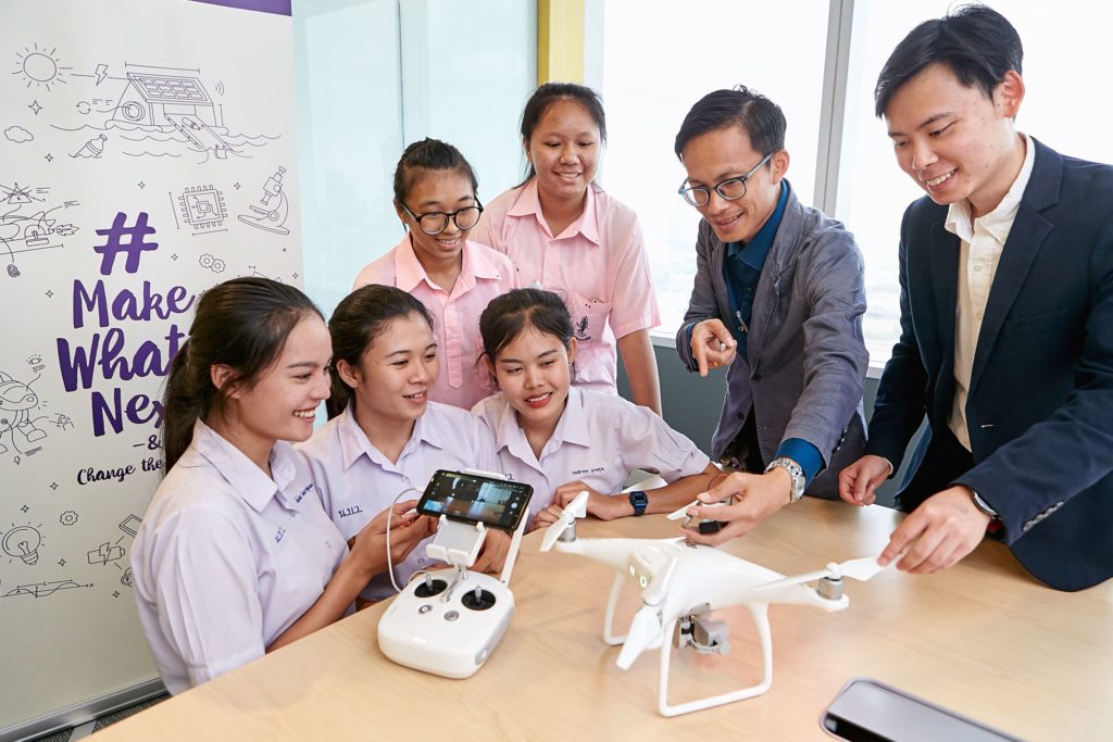 Group of people looking at drone and controller