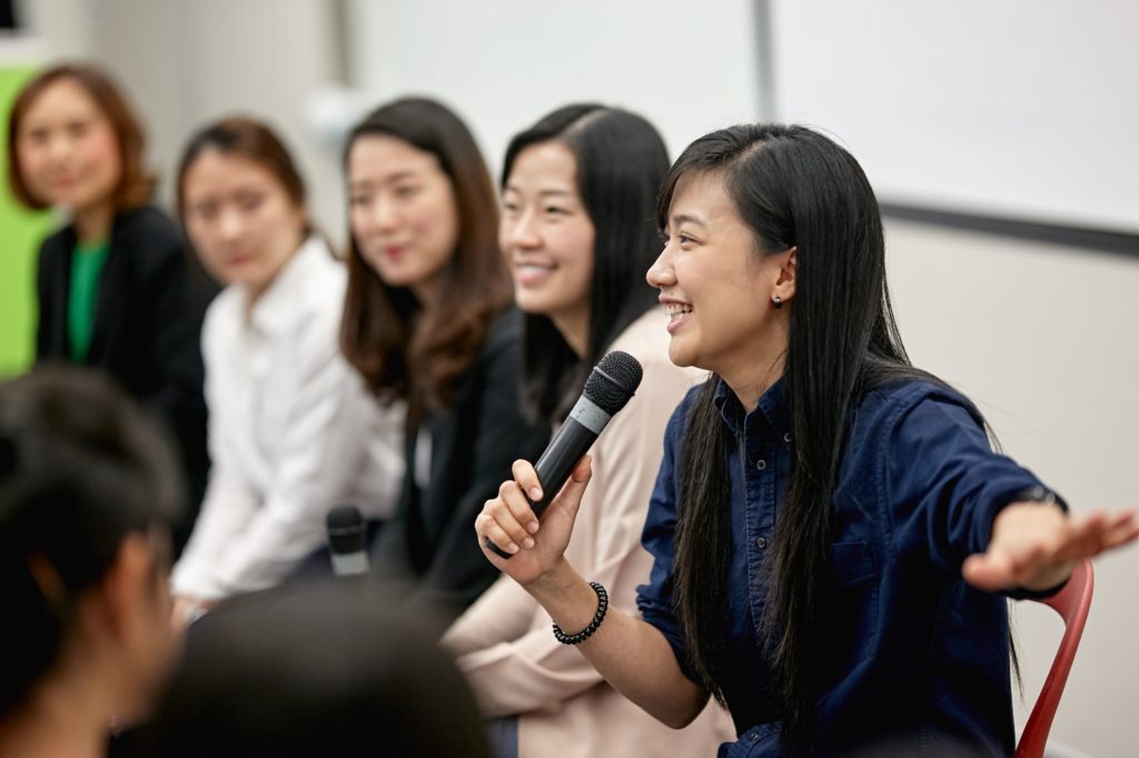 Smiling woman talking in panel discussion