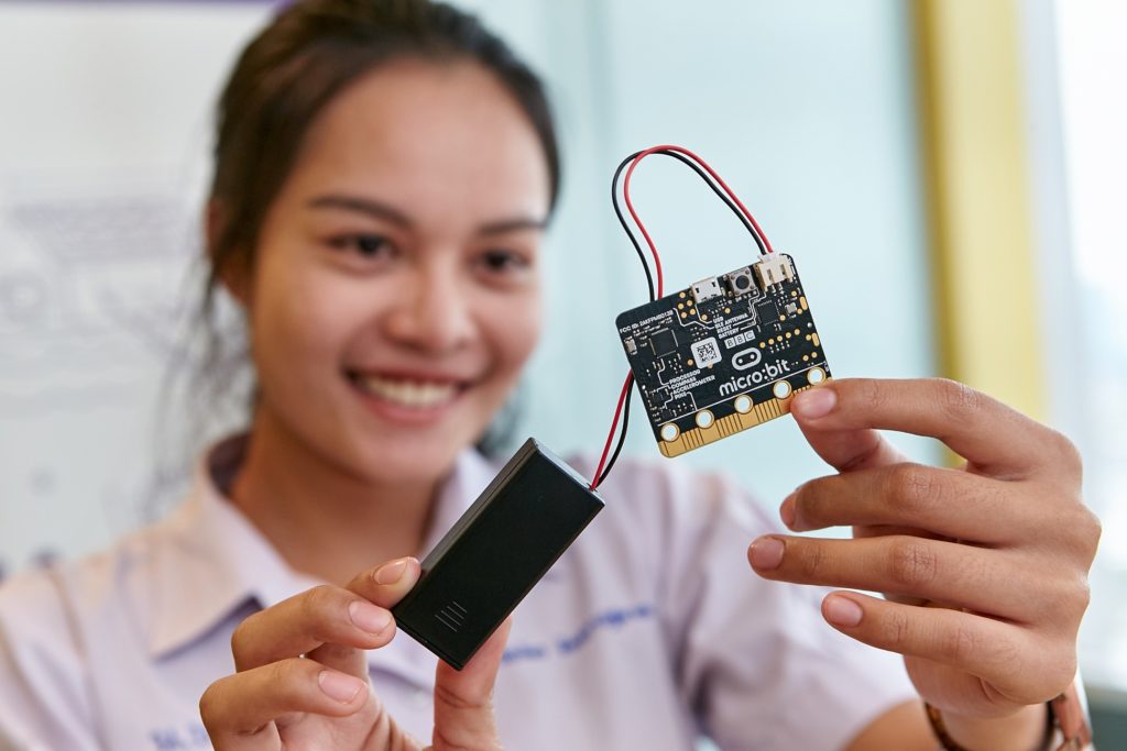 Smiling woman holding assembled circuit board
