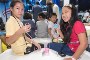 Two young girls holding micro:bit inventions