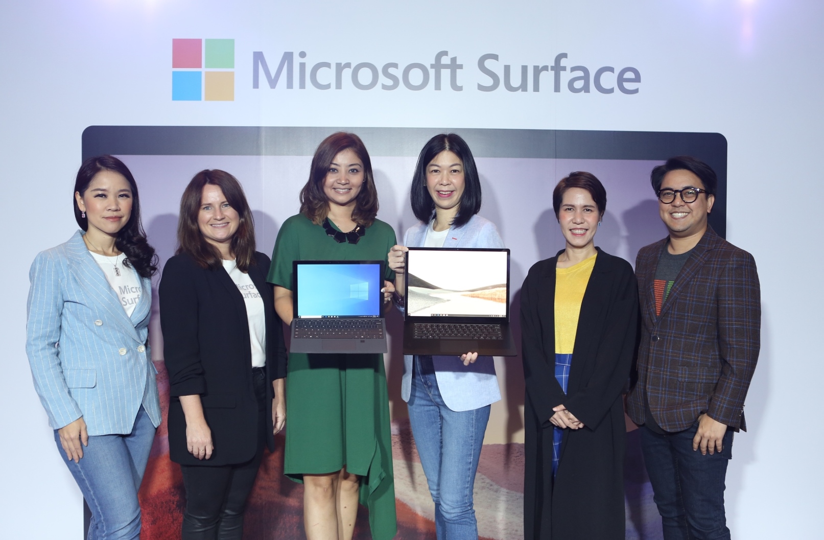 Group of executives and artist holding new Surface devices