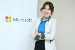 Smiling woman in white jacket with Microsoft sign