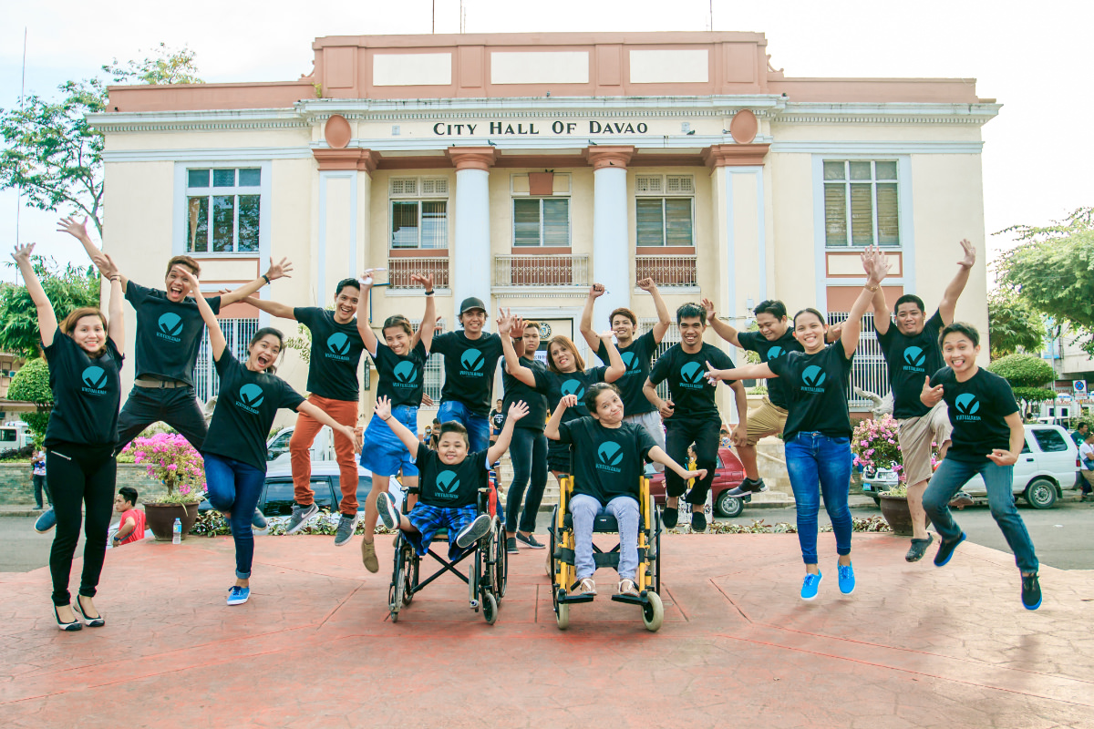 Group of young people with two in wheelchairs and the back row jumping