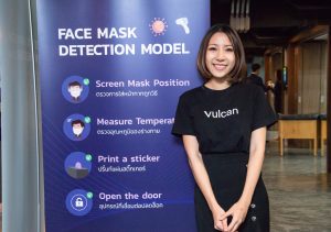 Smiling woman in front of blue/purple sign saying "Face Mask Detection Model"