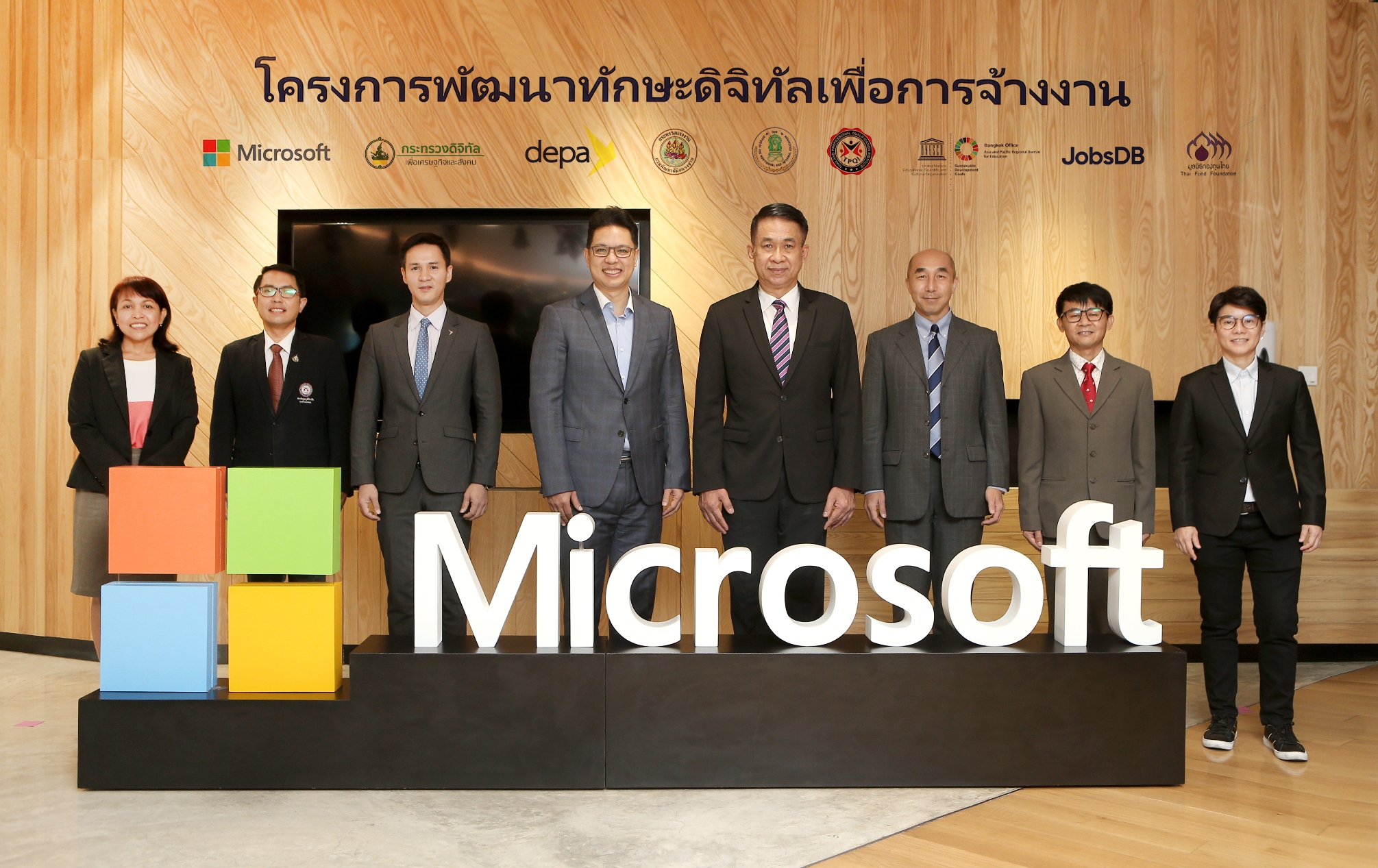 Group of executives standing with 3D Microsoft logo