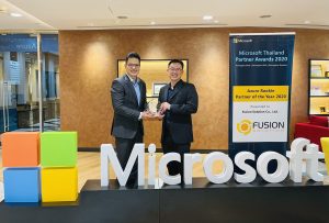 Two men behind Microsoft logo signage