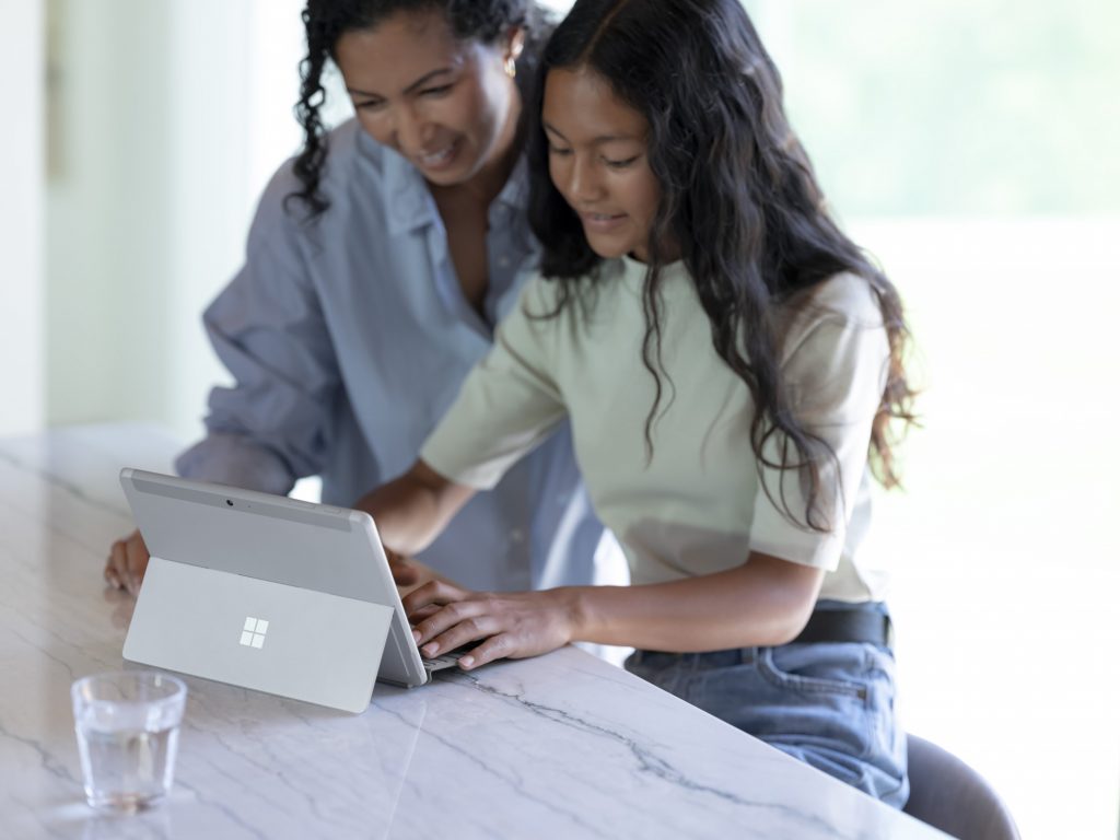 Woman and teen girl use a Surface Go 3 together