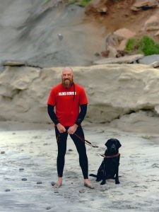 犬と共にビーチに立つジョシュアさん