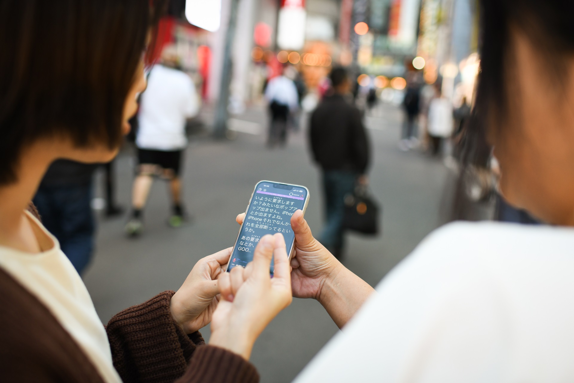聴覚情報処理障害のある添田洋美さんとアプリの開発元である株式会社アイシンの大場美乃里さんが、街中でアプリを使用しながら会話している様子。写真: 林典子 for Microsoft