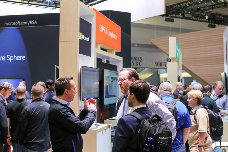 A Microsoft spokesperson speaks with attendees at the Microsoft booth at the RSA Conference.