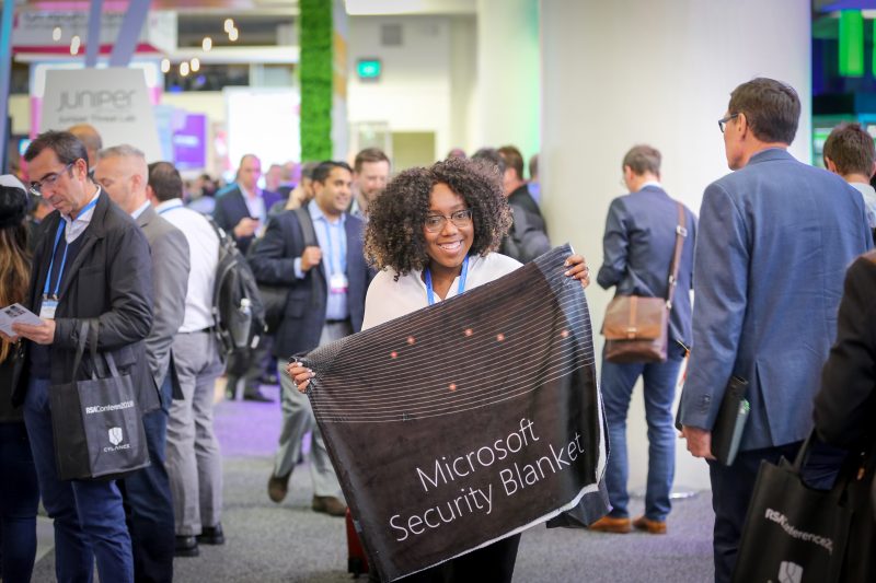 Jessica Afeku, Microsoft product marketing manager, holds up a “Microsoft security blanket,” distributed at the company’s booth at RSA on April 17, 2018.
