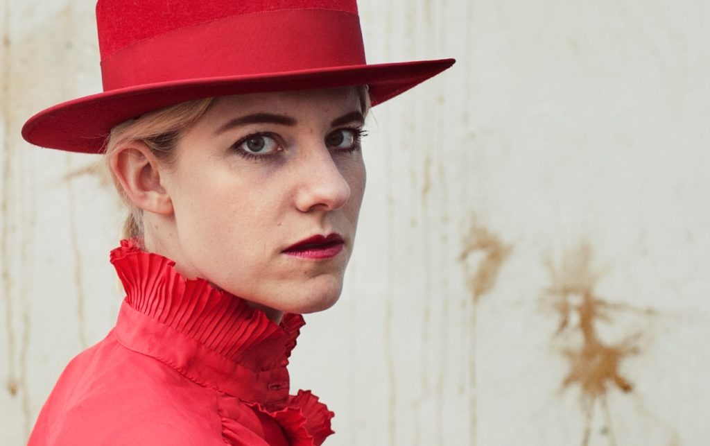 Digital kunstner Cecilie Falnkenstrøm iført rød hat og skjorte