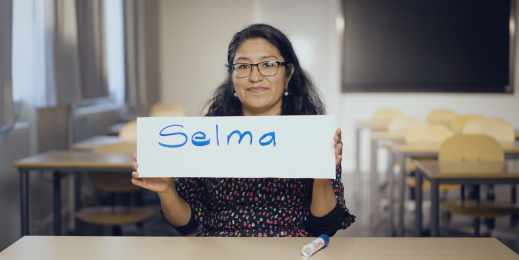 woman holds sign with name of her daughter : Selma