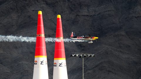 A Red Bull-sponsored race plane flies between two vertical pylons
