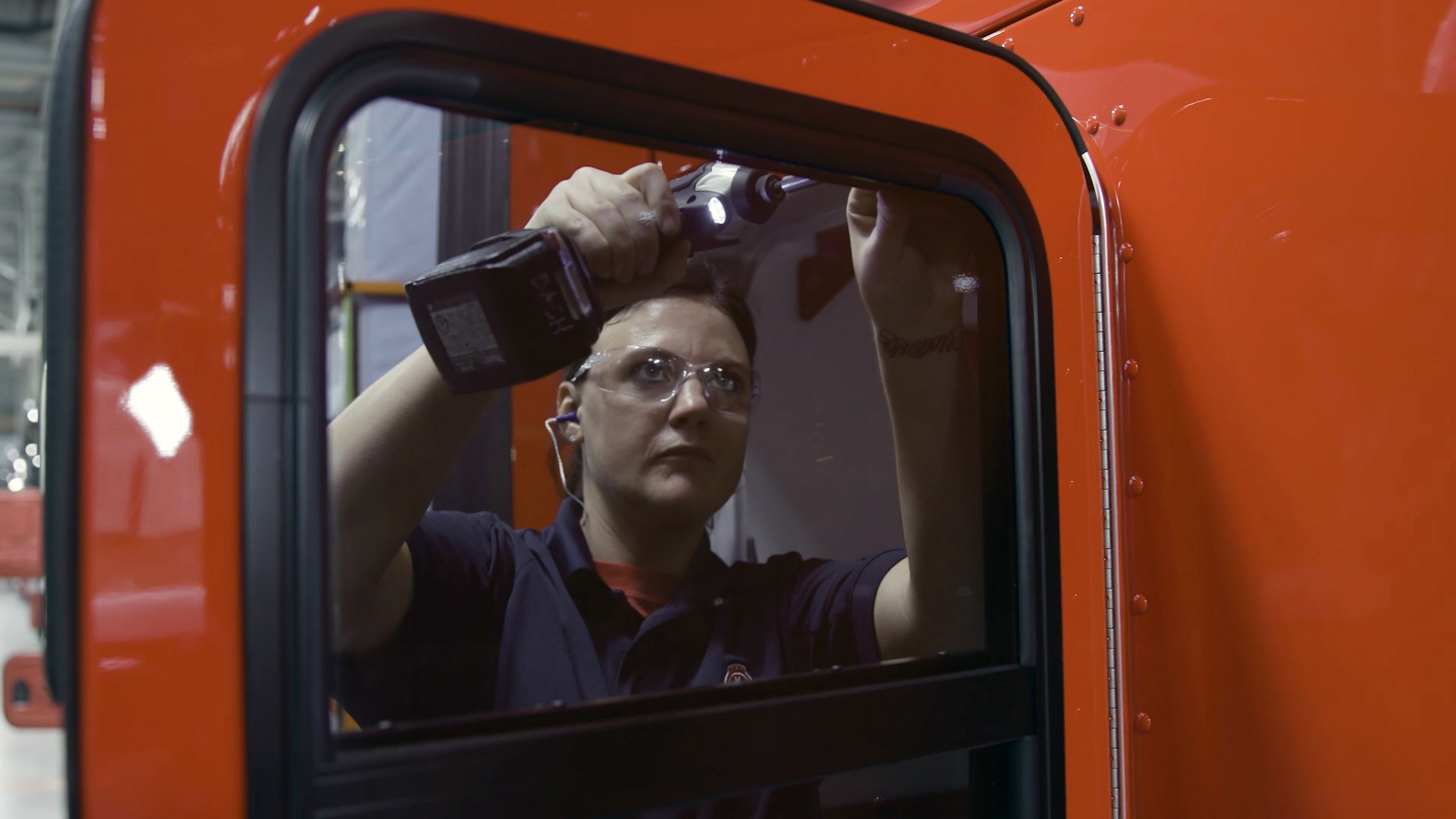 PACCAR employee Chelsey Potts assembles a truck door with a wireless drill