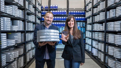 In a Warner Brothers cold storage room, Brad Collar, holding film cannisters, and Vicky Colf, holding a piece of silica glass, both containing the 1978 movie 'Superman'