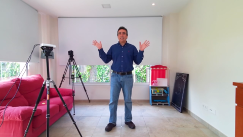 David Carmona standing in his living room in front of cameras