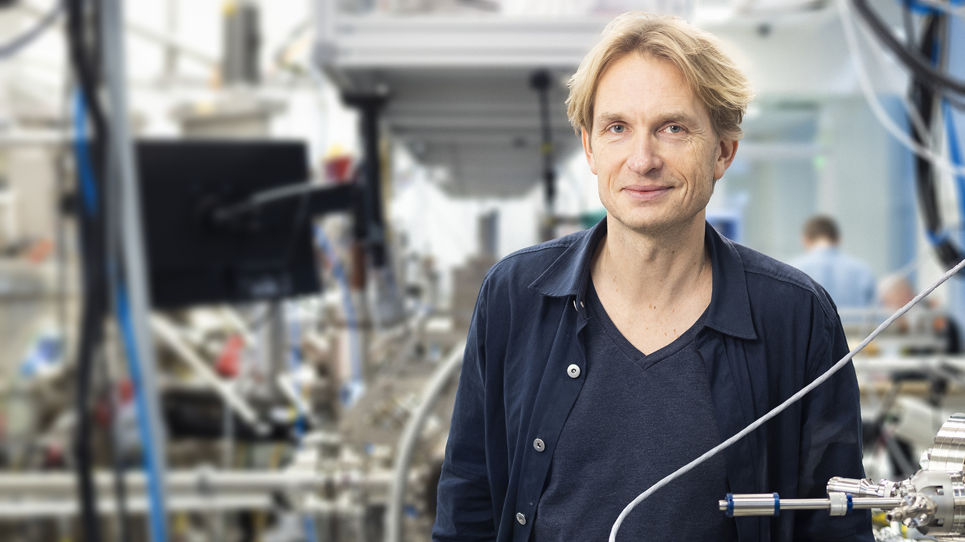 A man stands amidst quantum lab equipment