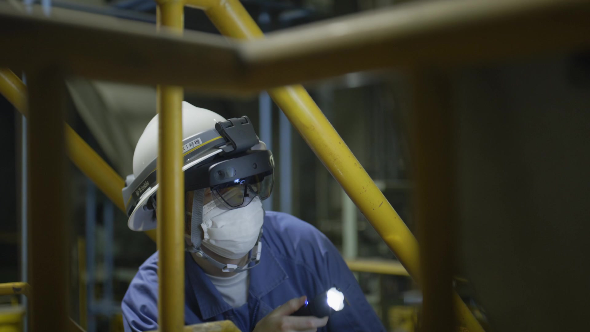 Un trabajador que usa un dispositivo HoloLens 2 enciende una linterna en un equipo. 