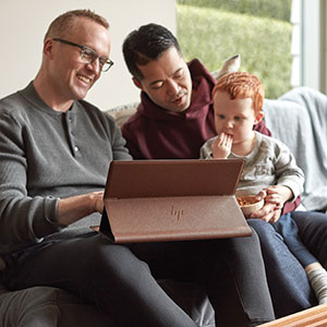 parents work with their young son using a surface book