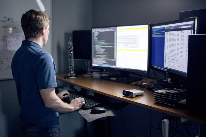 Man works on computer using two monitors and an Azure Kinect DK