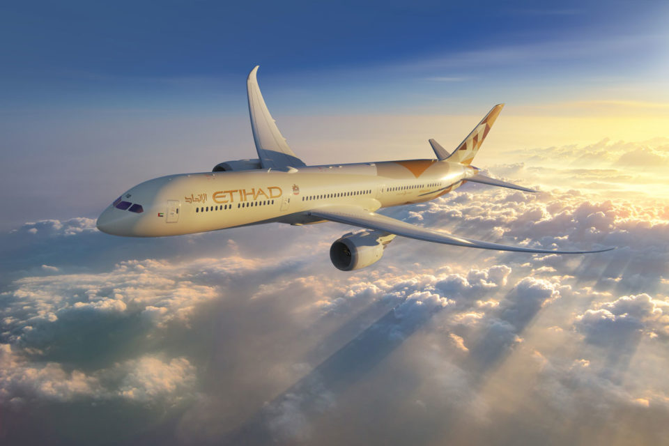 Picture of an Etihad airplane flying over the clouds.