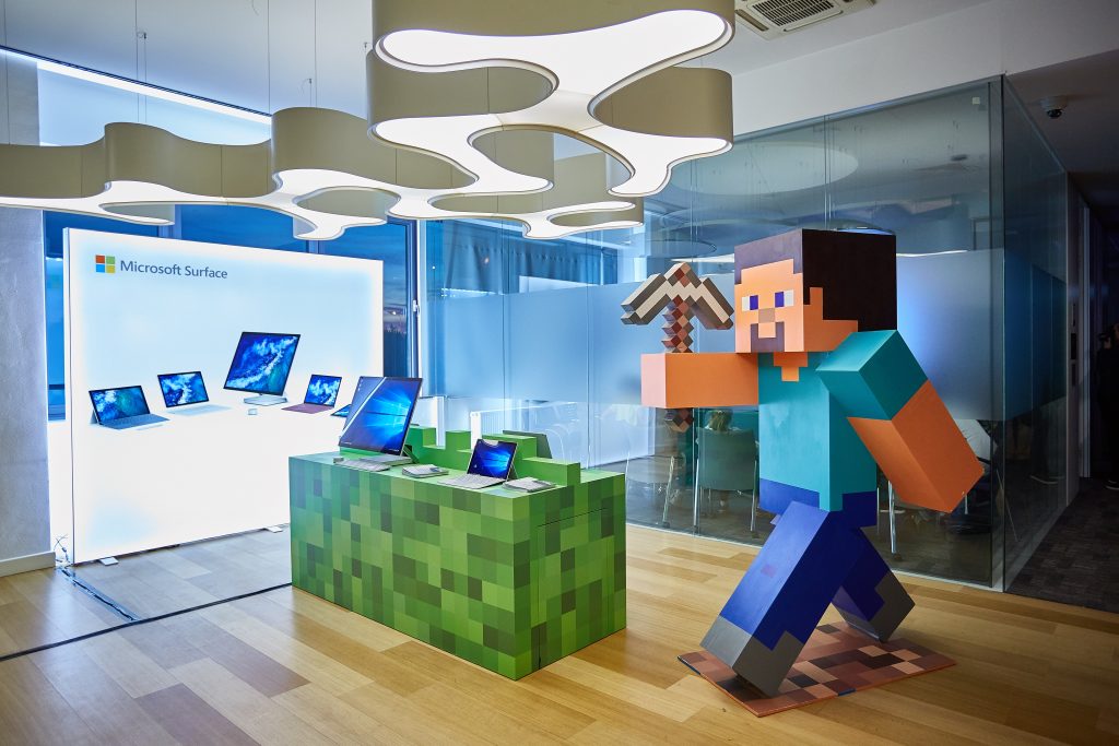 Minecraft table with Surface devices family and Minecraft Steve statue near by