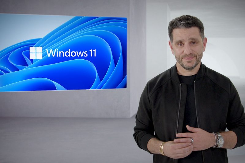 Man stands next to a Windows 11 screen