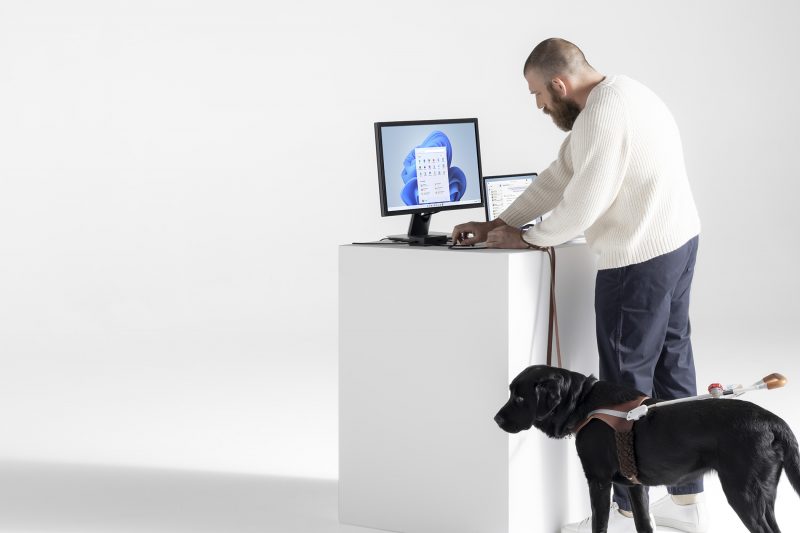 A man using the Surface Adaptive Kit with a dog standing near