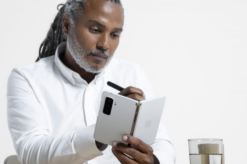 A man holding a white Surface Duo 2 phone