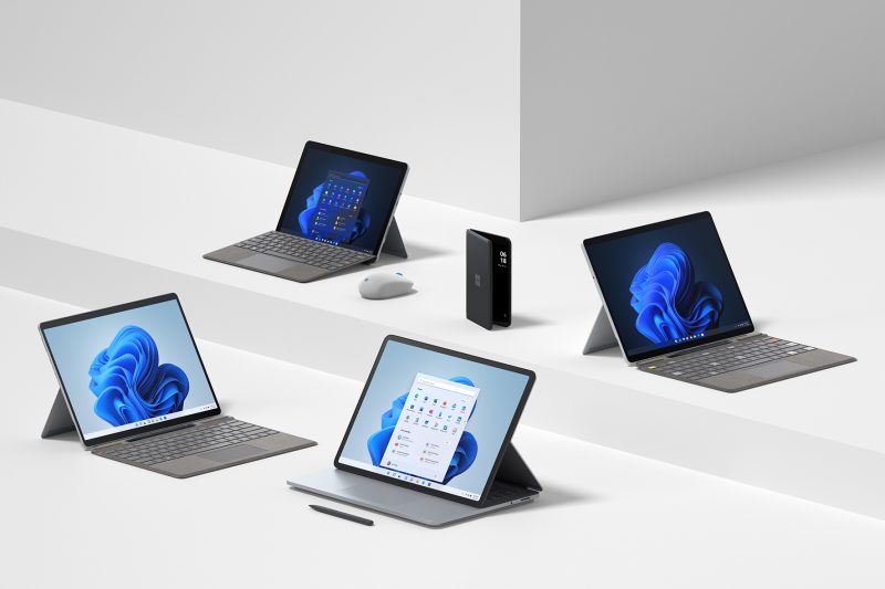 Four Surface devices, a Surface pen, a mouse, and a phone
