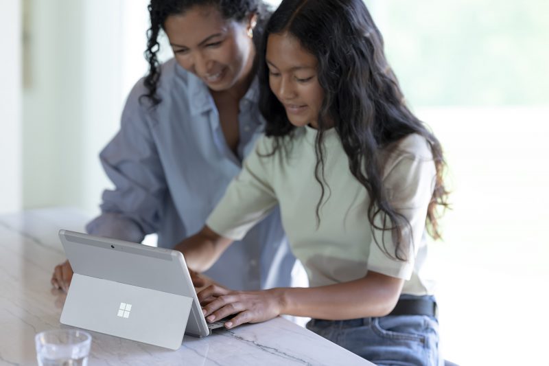 Two people use a Surface Go 3 device