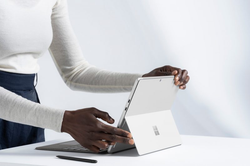 A person opening a Surface Pro 8