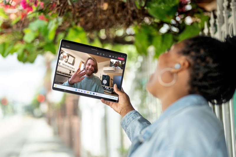 A person holds a tablet computer while video calling a friend.