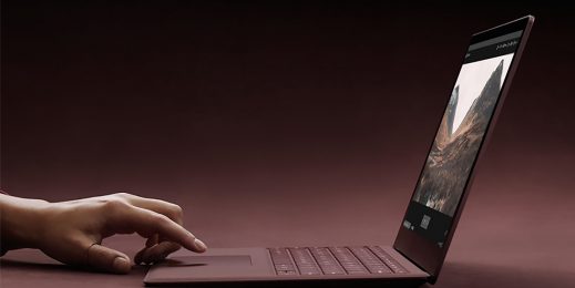 Hand poised over the touch pad of Surface device
