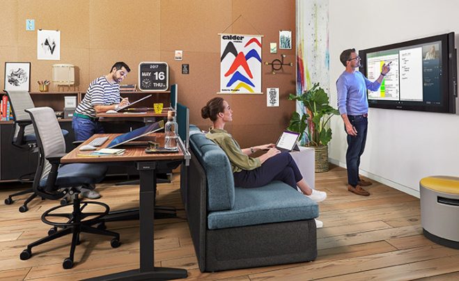 Three people collaborating around a Surface Hub