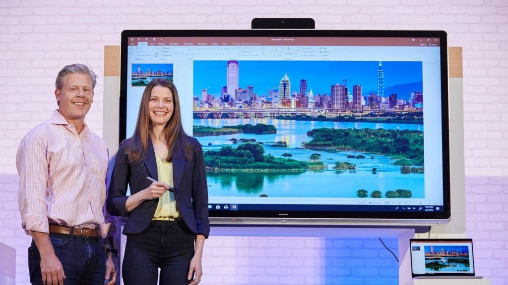 Man and Woman in front of a surface hub