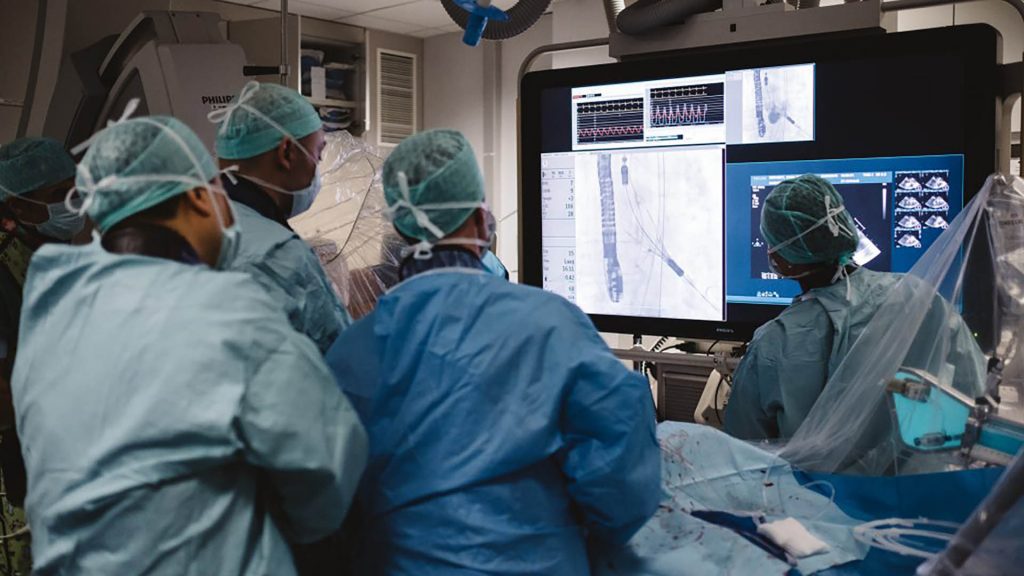 surgeons performing a surgery looking at a screen