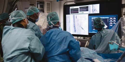 surgeons performing a surgery looking at a screen