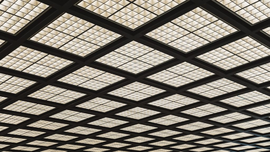 Up angle view of gridded square fluorescent lights in financial office