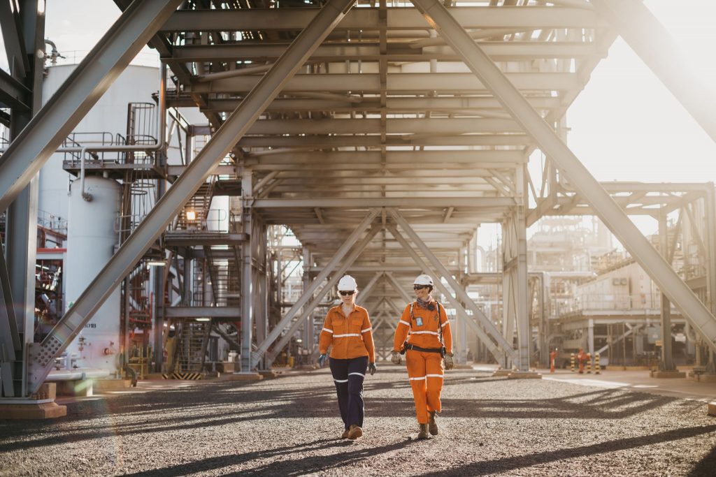 Two workers walking outside onshore plant